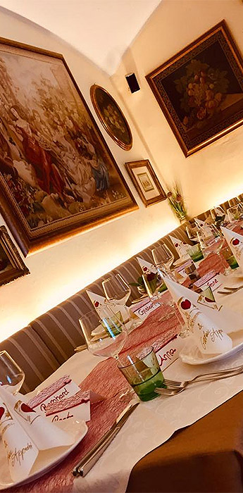 Ein gedeckter Tisch mit Besteck, Tellern, Gläsern und Servietten